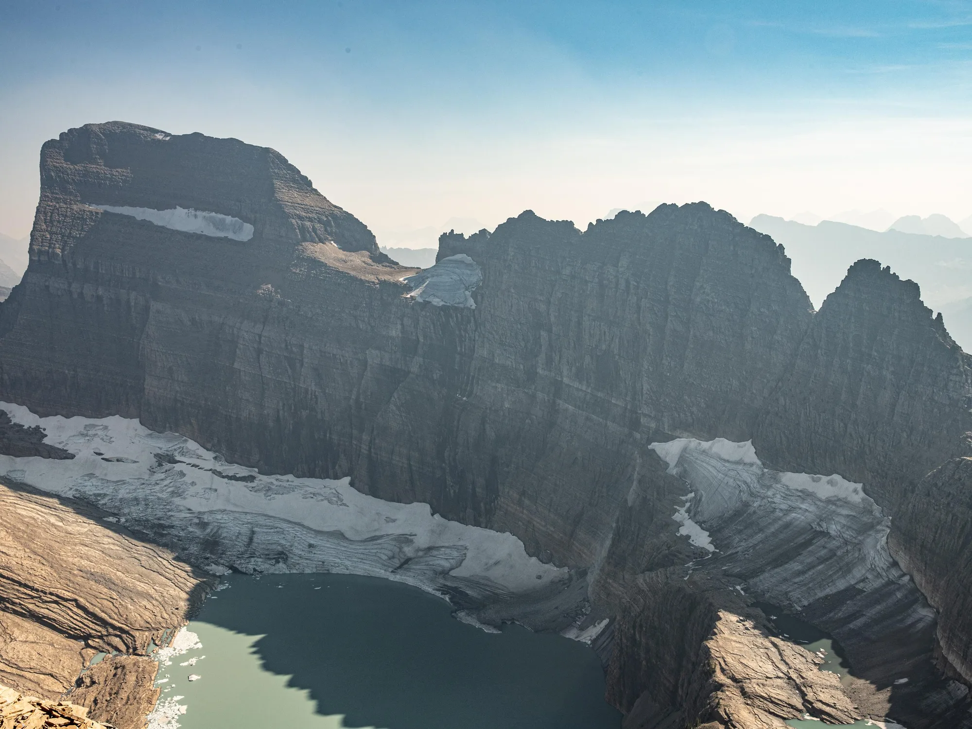A boardwalk crossing alpine tundra beneath mountain peaks in Glacier National Park