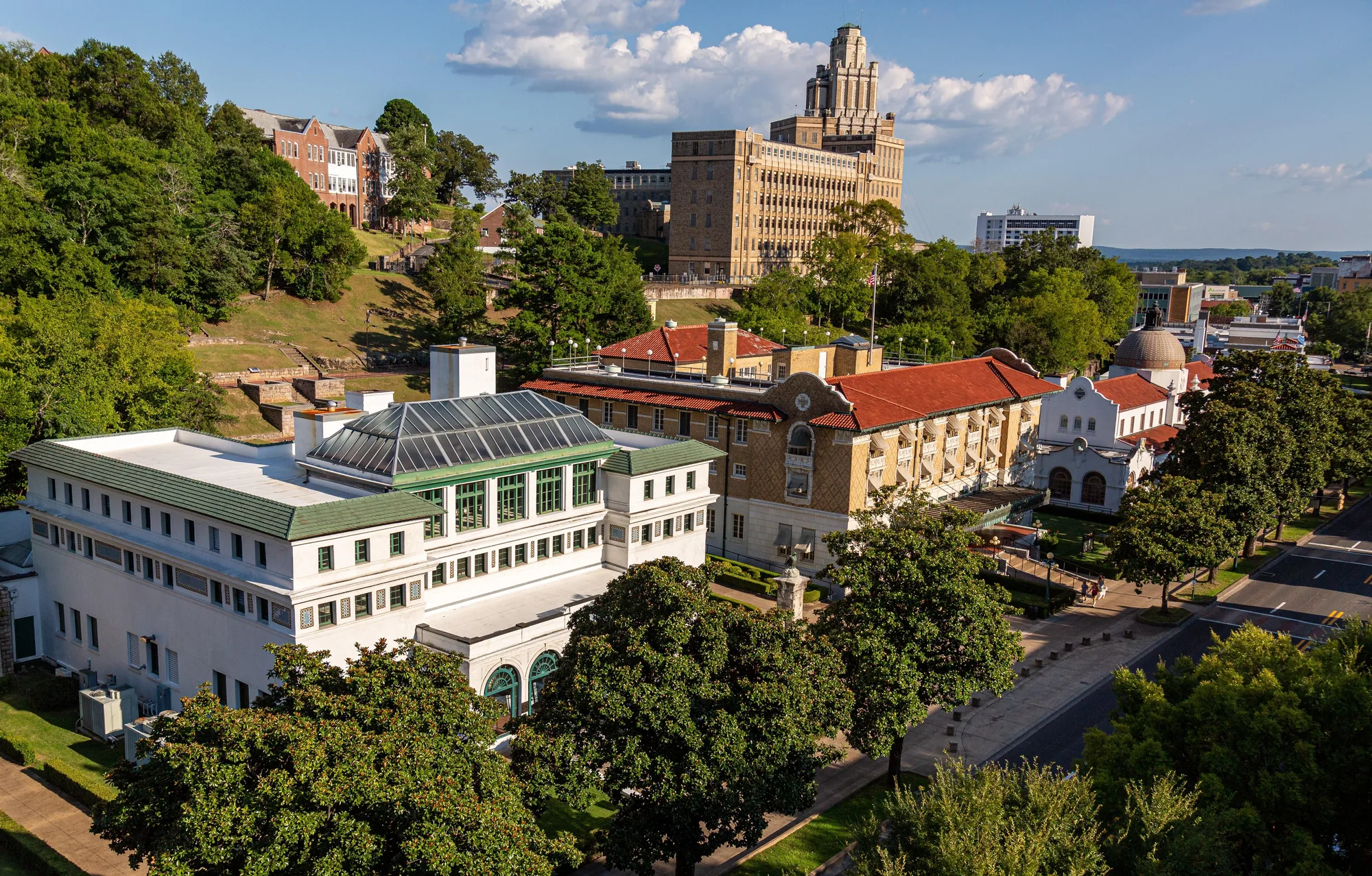 Bathhouse Row and downtown Hot Springs seen from above, with the forested Ouachita Mountains rising behind